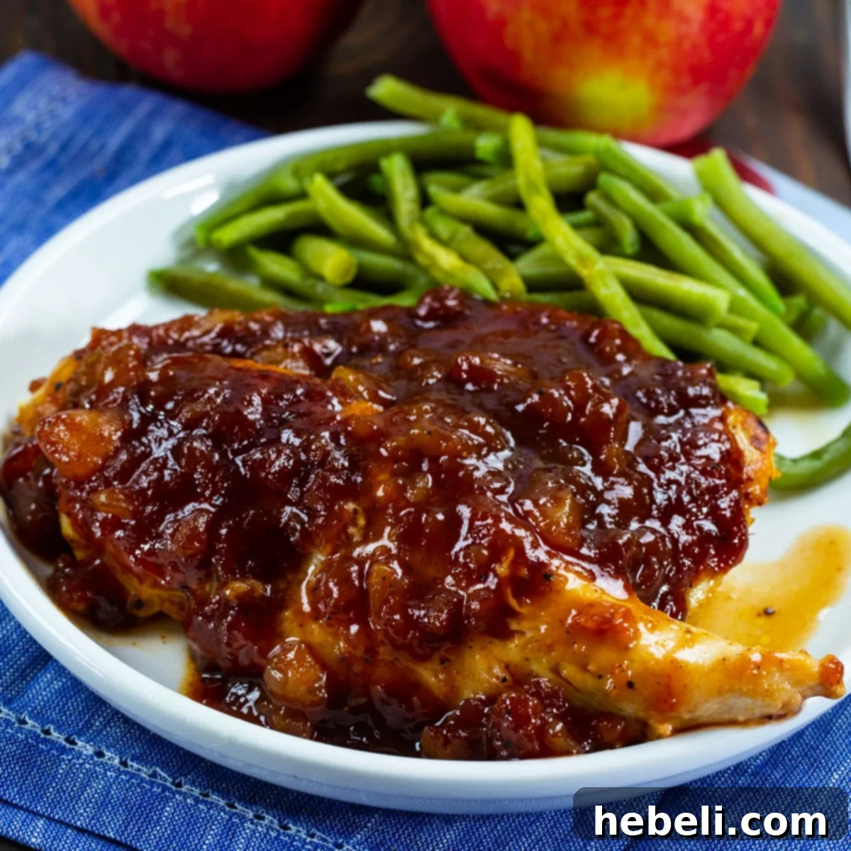 Applesauce BBQ Chicken on a plate with green beans and a fork.