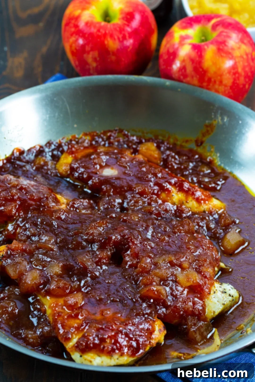 BBQ Chicken simmering in an oven-safe skillet.