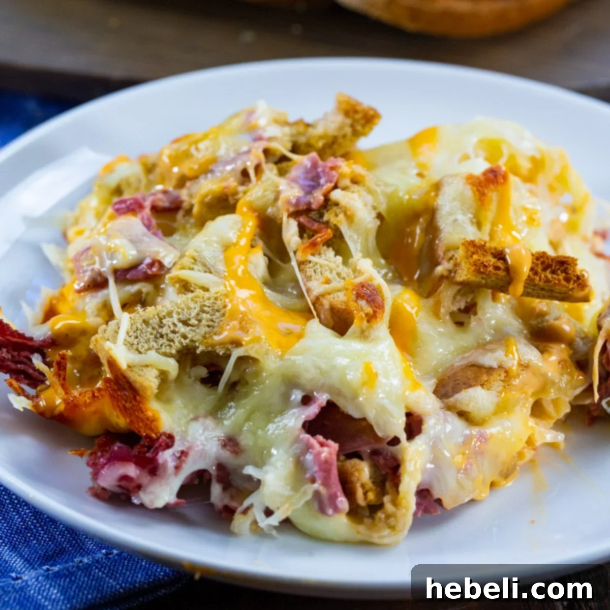The Ultimate Reuben Casserole 2 Reuben Casserole dished up on a plate, showcasing melted cheese and savory ingredients.