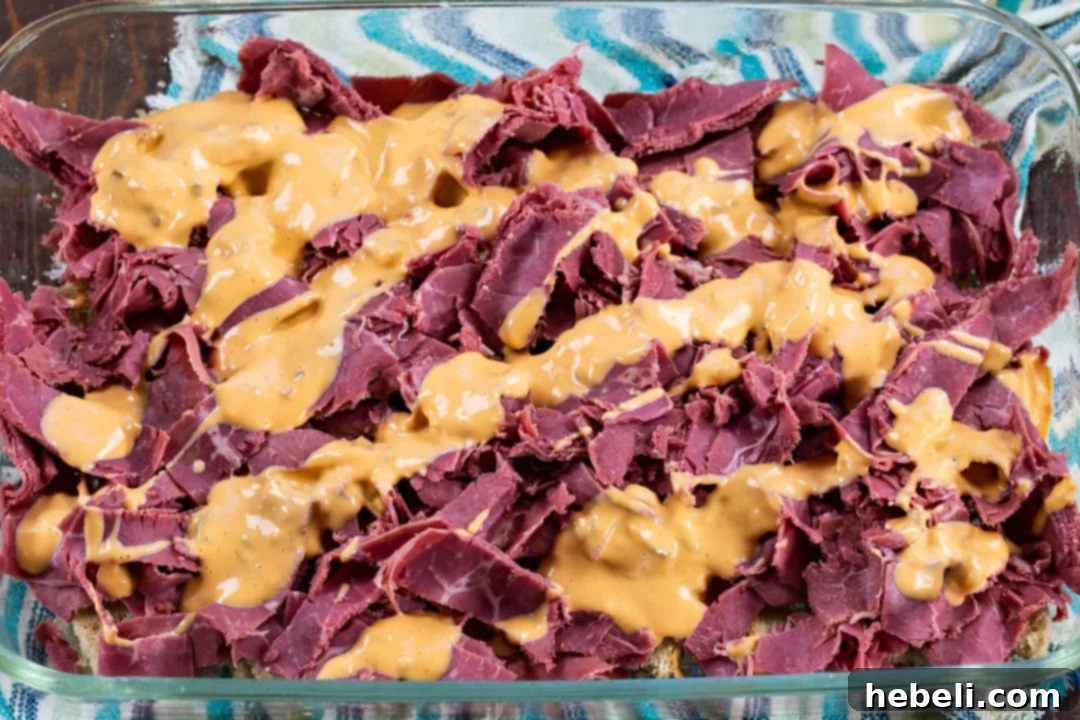 The Ultimate Reuben Casserole 6 Thousand Island dressing drizzled generously over the corned beef layer in the casserole.