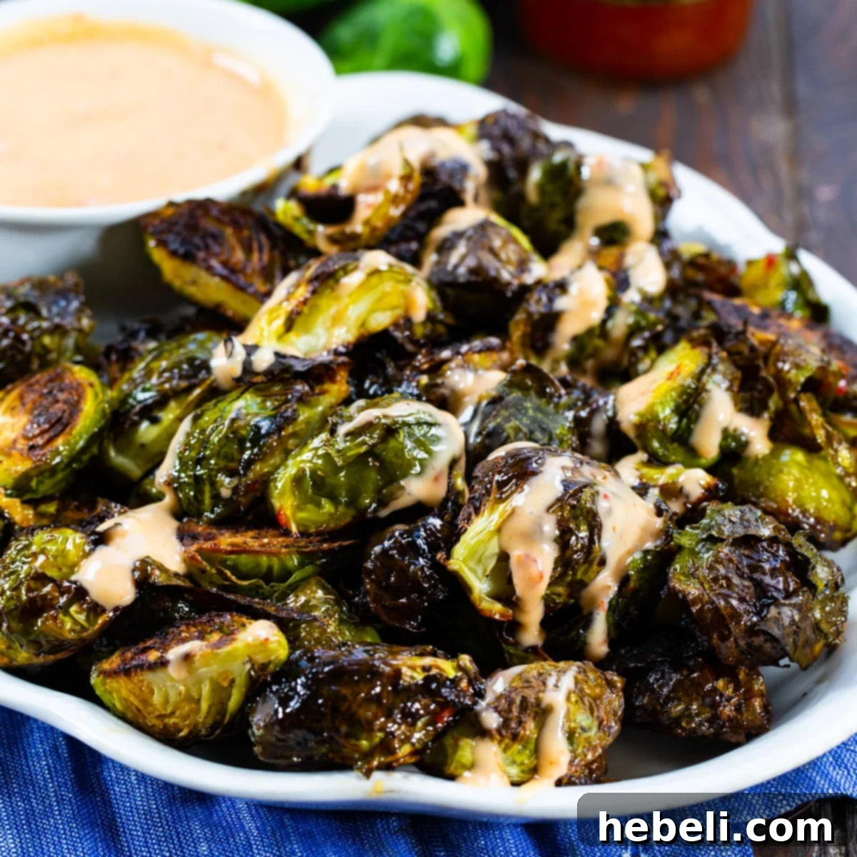 Perfectly roasted Bang Bang Brussels Sprouts on a rustic serving plate, ready to be enjoyed.