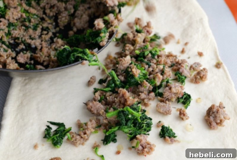 Savory Sausage and Spinach Swirl 7 Spreading the savory sausage and spinach filling across the center of the rolled-out dough.