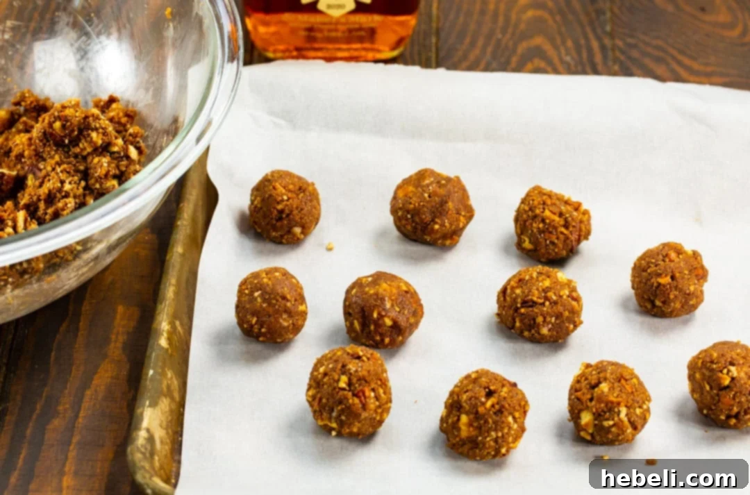 Freshly rolled Vanilla Wafer Bourbon Balls resting on parchment paper on a baking tray, ready for chilling and coating.