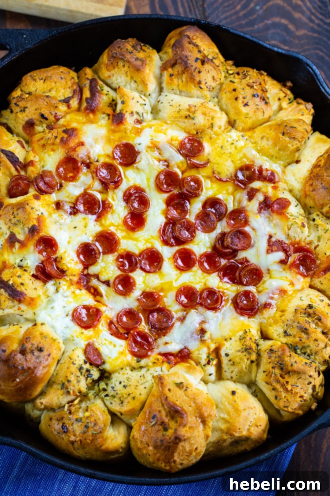 Close-up of Pizza Dip Ring with golden biscuit balls and melted cheese topped with mini pepperonis.