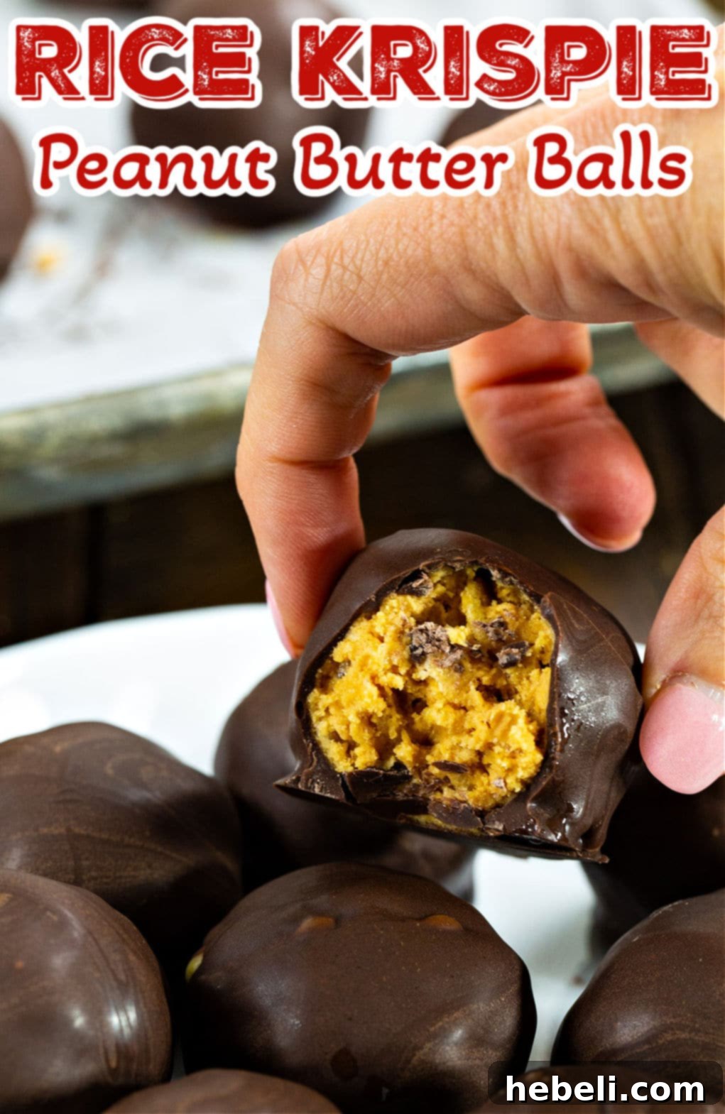 Peanut Butter Krisp Wonders 4 A hand reaching for a chocolate-coated Rice Krispie Peanut Butter Ball from a platter.