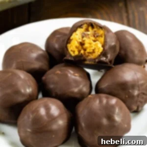 Four Rice Krispie Peanut Butter Balls stacked on top of each other, showcasing their perfect chocolate coating and deliciousness.