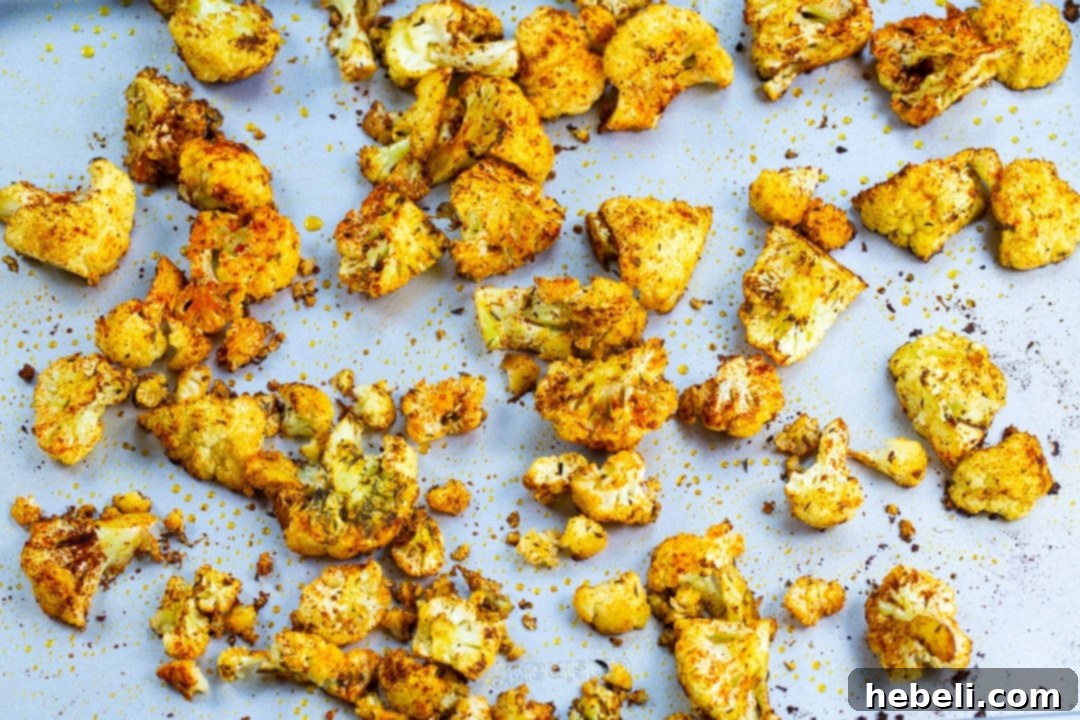 Fiery Cajun Cauliflower Bites 3 Close-up view of seasoned cauliflower florets spread evenly on a baking sheet, ready for roasting to achieve perfect crispness.
