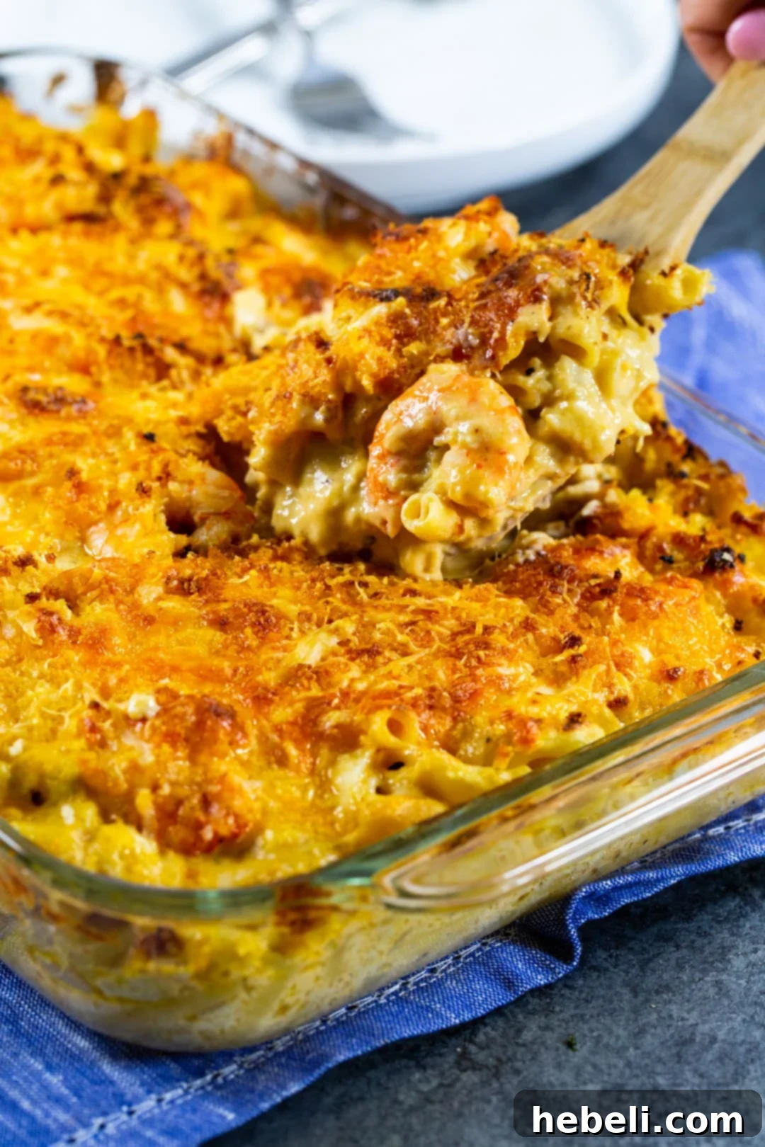 Close-up shot of a spoon scooping creamy Cajun Shrimp and Crab Mac and Cheese, highlighting the rich texture and seafood pieces.