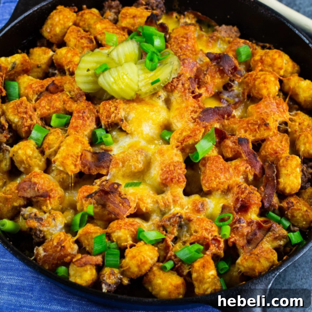 Cheeseburger Tater Tot Casserole in a cast iron pan, ready to be served.