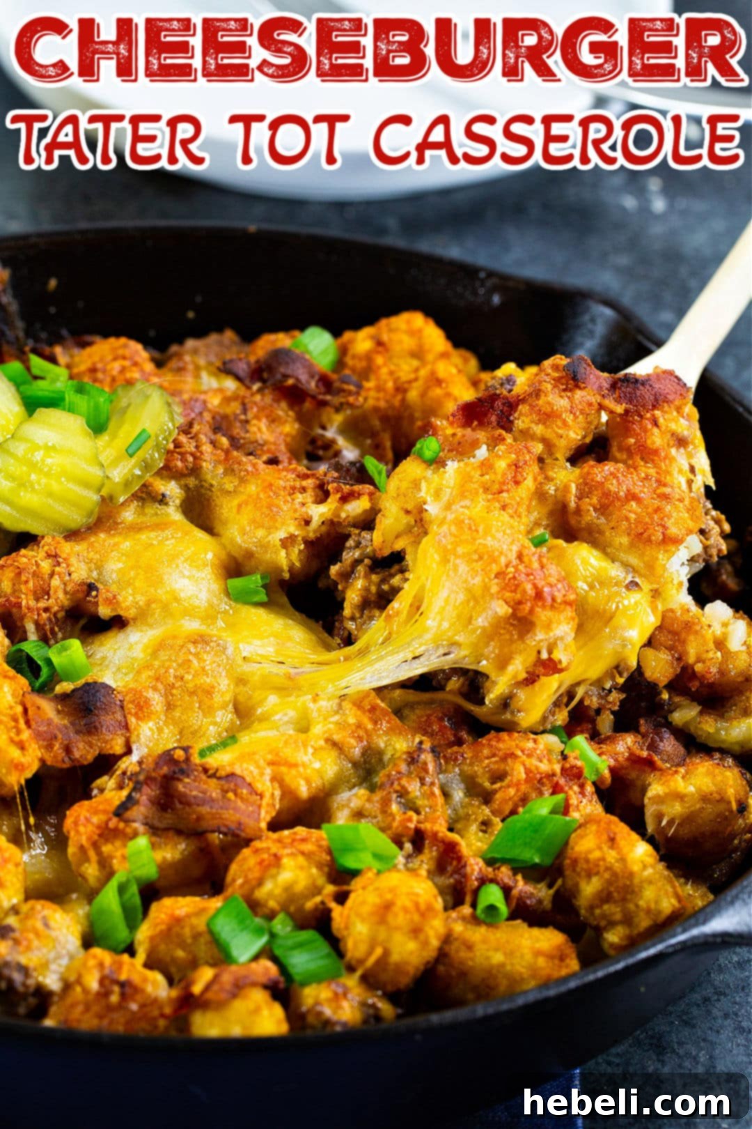 Spoon scooping up a portion of Cheeseburger Tater Tot Casserole from the pan.