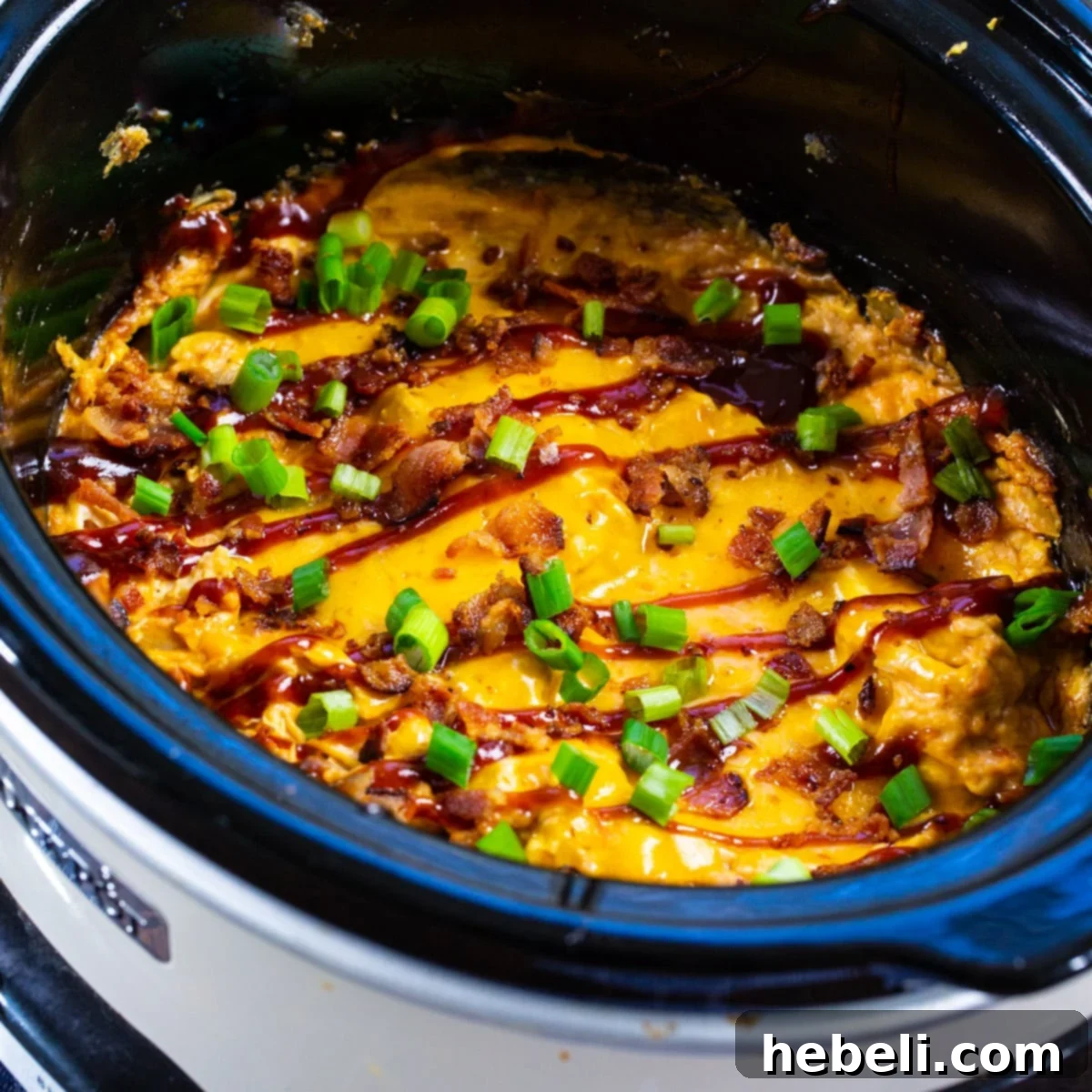 Slow Cooker BBQ Chicken Dip in a crock pot, garnished with fresh herbs.