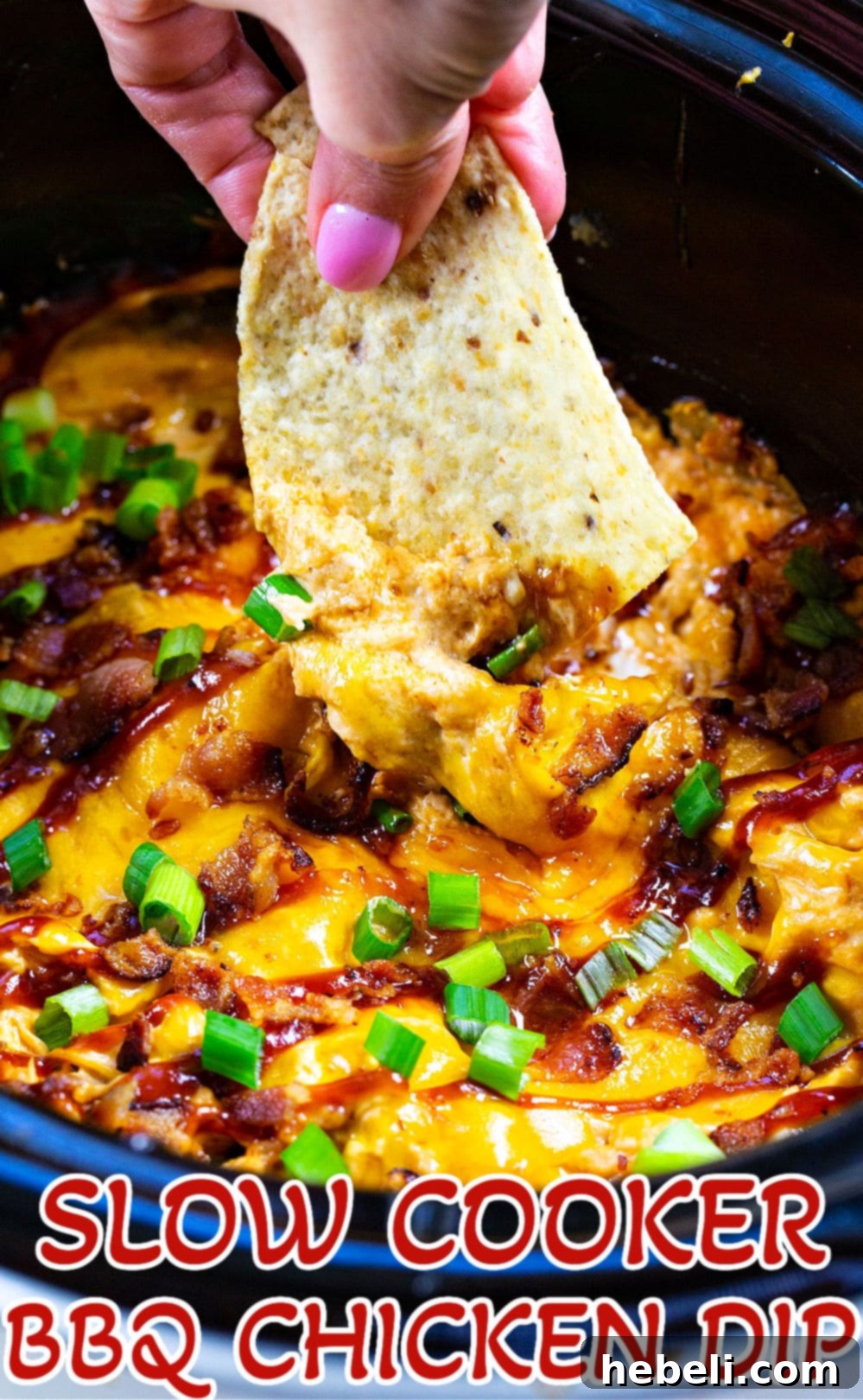 Tortilla chip being dipped into the creamy Slow Cooker BBQ Chicken Dip.