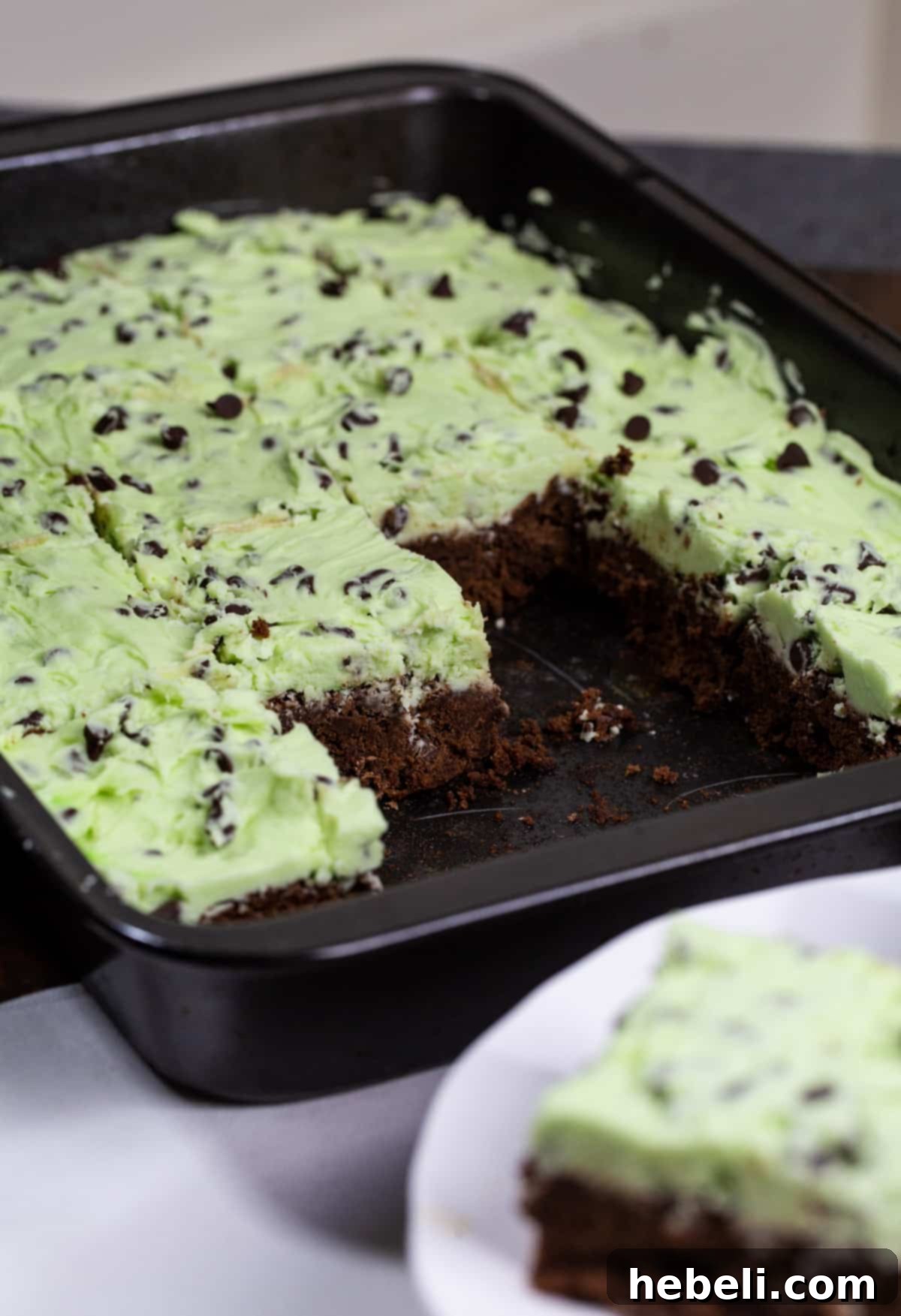 Decadent Creme de Menthe Chocolate Chip Brownies 3 A baking dish filled with freshly baked brownies, generously topped with vibrant Creme de Menthe-Chocolate Chip Frosting.