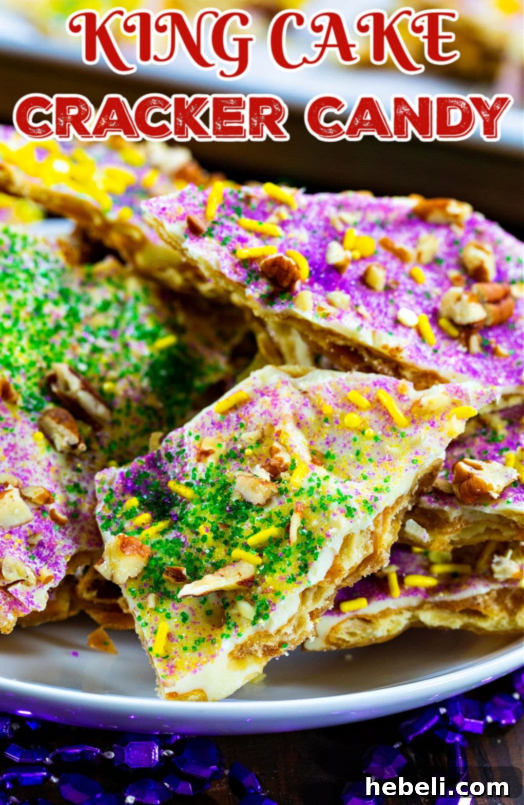 King Cake Toffee Bark 5 Cracker Candy broken into various pieces and artistically arranged on a plate.