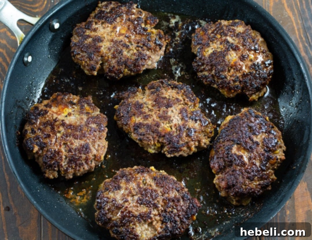 Bourbon Mushroom Gravy Hamburger Steaks 4 Raw ground beef patties shaped and ready for cooking in a skillet.