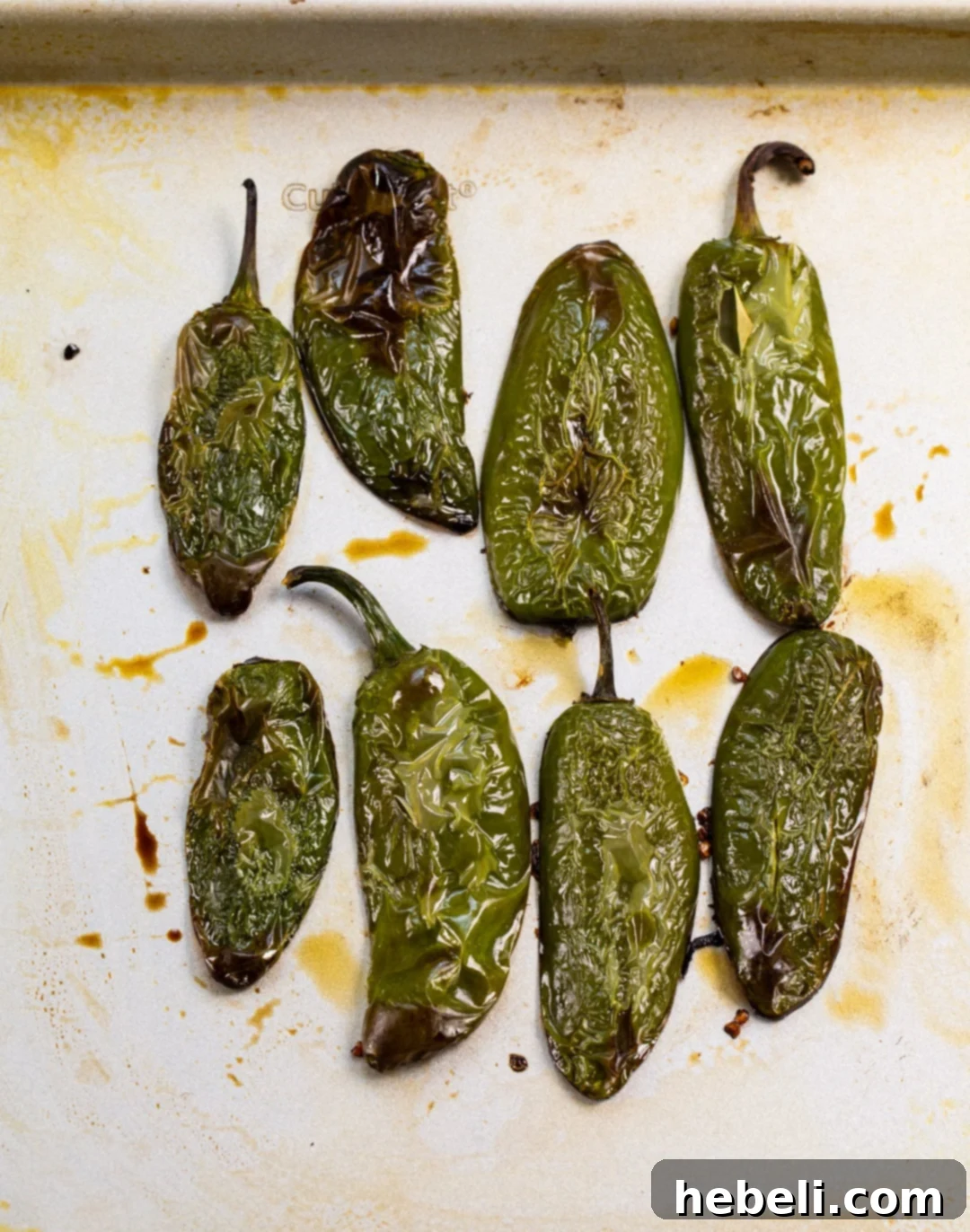 Freshly roasted jalapenos, showing their softened texture and slight char, ready to be incorporated into the creamy filling.