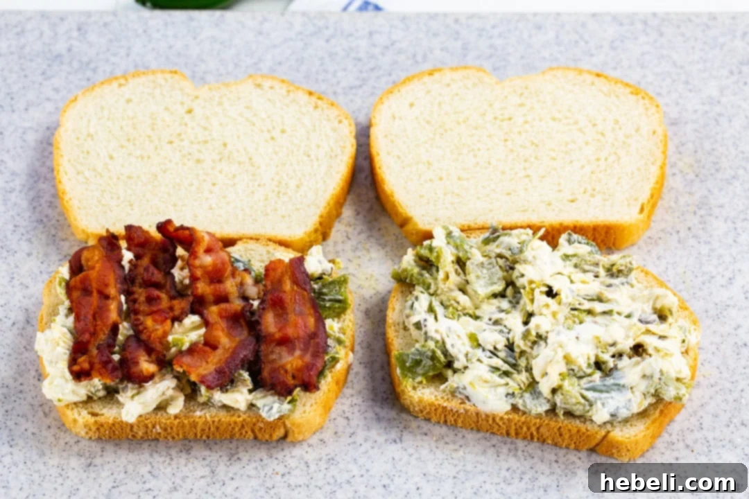 Two slices of bread, one side buttered, are shown with the creamy jalapeno and cream cheese mixture spread generously on the unbuttered side.