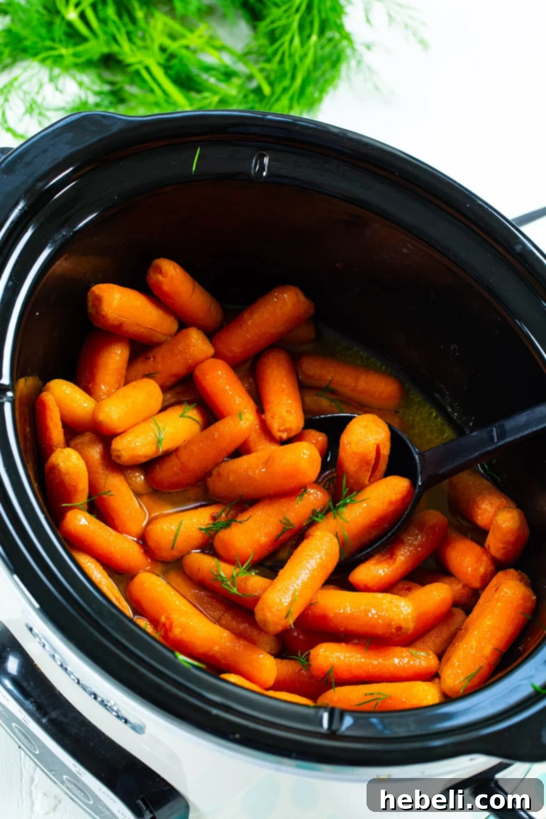 Baby Carrots cooking in slow cooker, simmering in glaze.