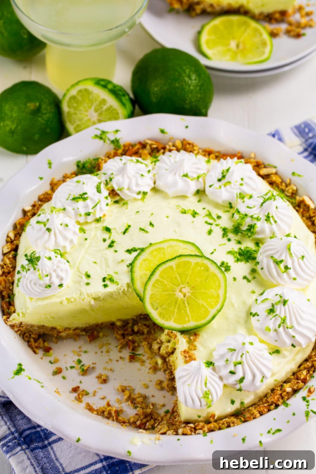 Effortless Margarita Dream Pie 3 Close-up view of a whole No-Bake Margarita Pie, garnished with lime, sitting in a pie pan.