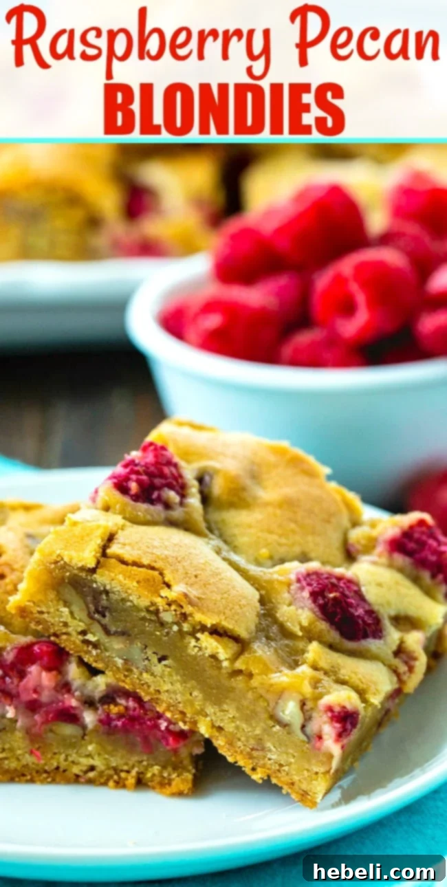 Two bars on a white plate with a bowl of fresh raspberries in the background, showing a close-up of the delicious texture.