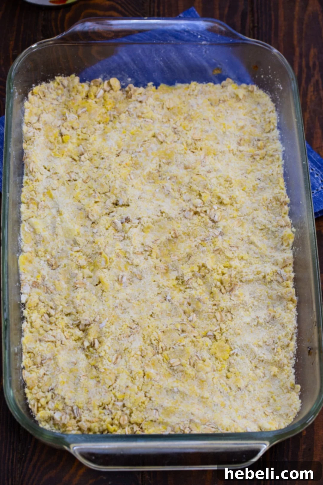 The delicious oat crust is pressed firmly into a 9x13-inch baking dish, ready for its peach topping.