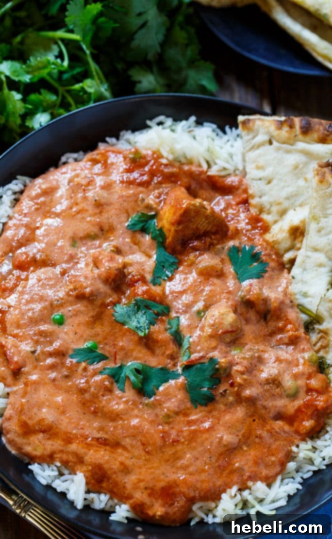 Effortless Slow Cooker Chicken Tikka 3 Homemade Chicken Tikka Masala served over fluffy rice, garnished with fresh cilantro.