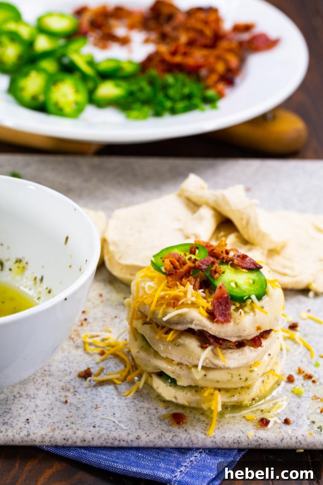 Spicy Cheesy Pull-Apart Perfection 4 Biscuit pieces stacked with cheese, bacon, and jalapenos.