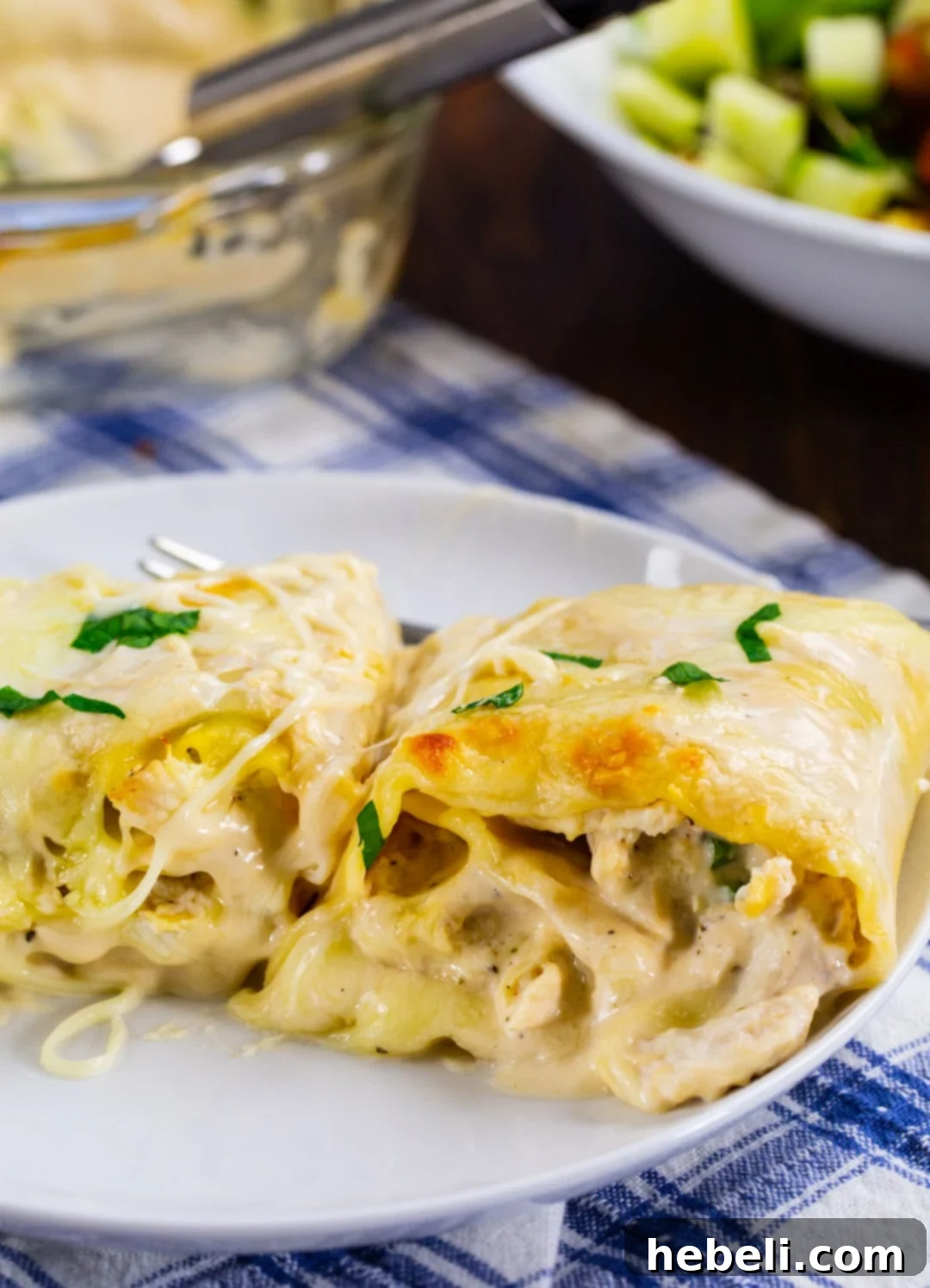 Alfredo Chicken Lasagna Pinwheels 6 Two perfectly rolled and baked Chicken Alfredo Lasagna Roll-Ups on a white plate, garnished with fresh parsley.