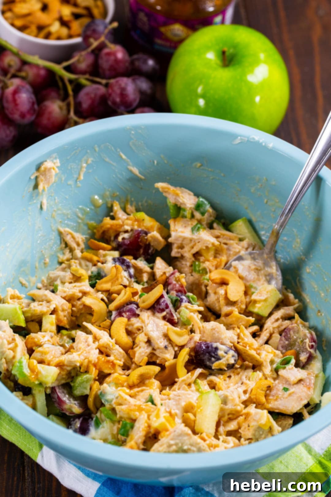 Exotic Mango Chicken Salad 3 Creamy Mango Chutney Chicken Salad being mixed in a large stainless steel bowl, showcasing the vibrant ingredients.