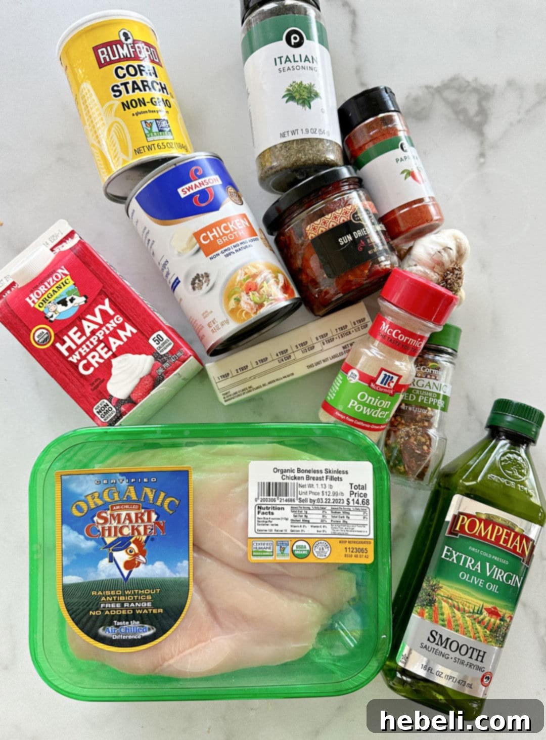 Slow Cooker Engagement Chicken 4 Ingredients for Slow Cooker Marry Me Chicken laid out on a kitchen counter: chicken breasts, sun-dried tomatoes, cream, broth, and spices.