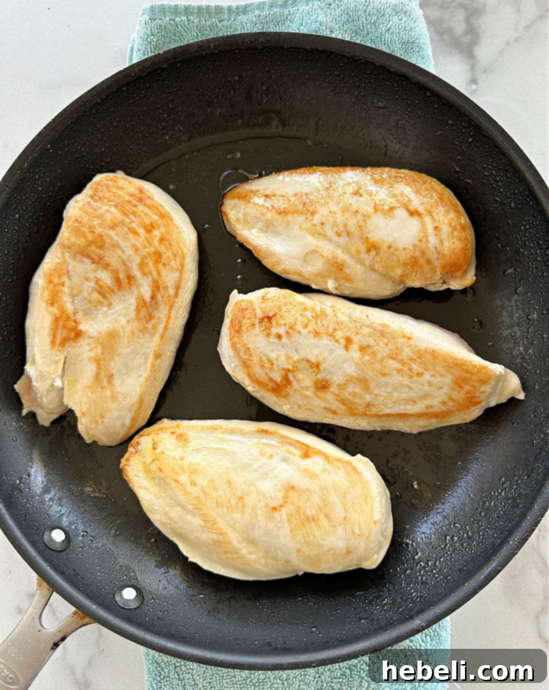 Slow Cooker Engagement Chicken 5 Chicken breasts browning in a nonstick skillet with a golden crust.