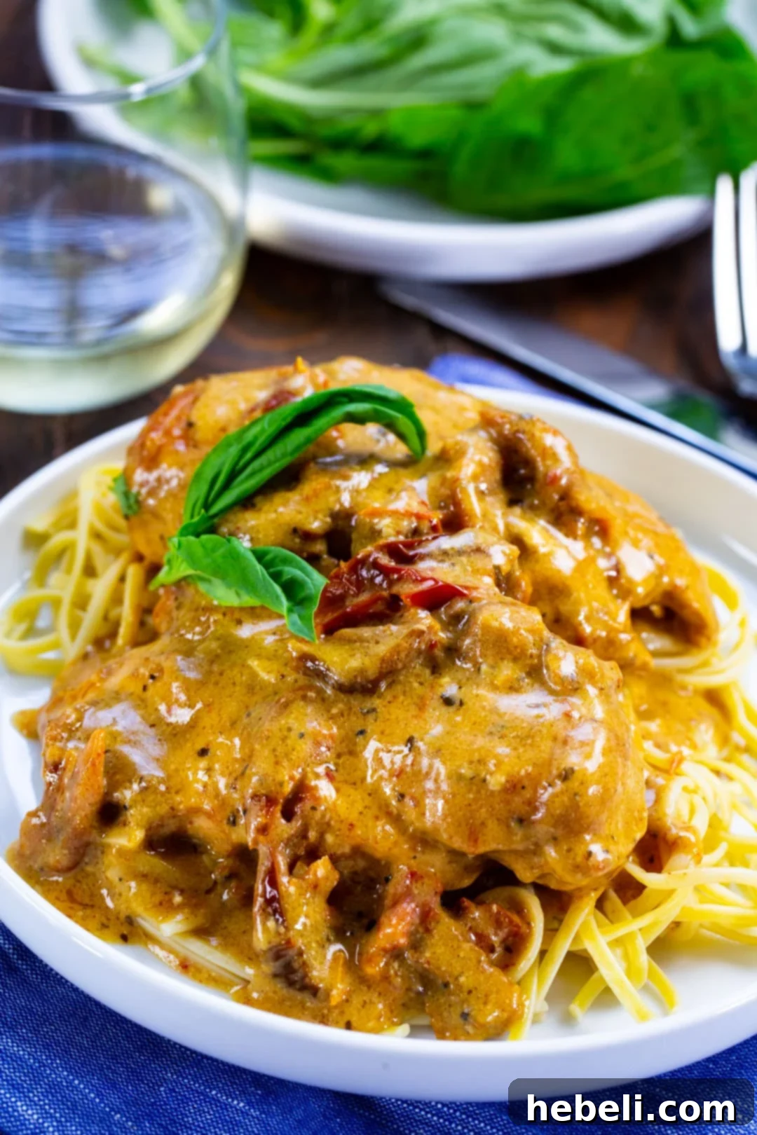 Slow Cooker Engagement Chicken 7 Close-up of Slow Cooker Marry Me Chicken served over pasta, garnished with fresh herbs.