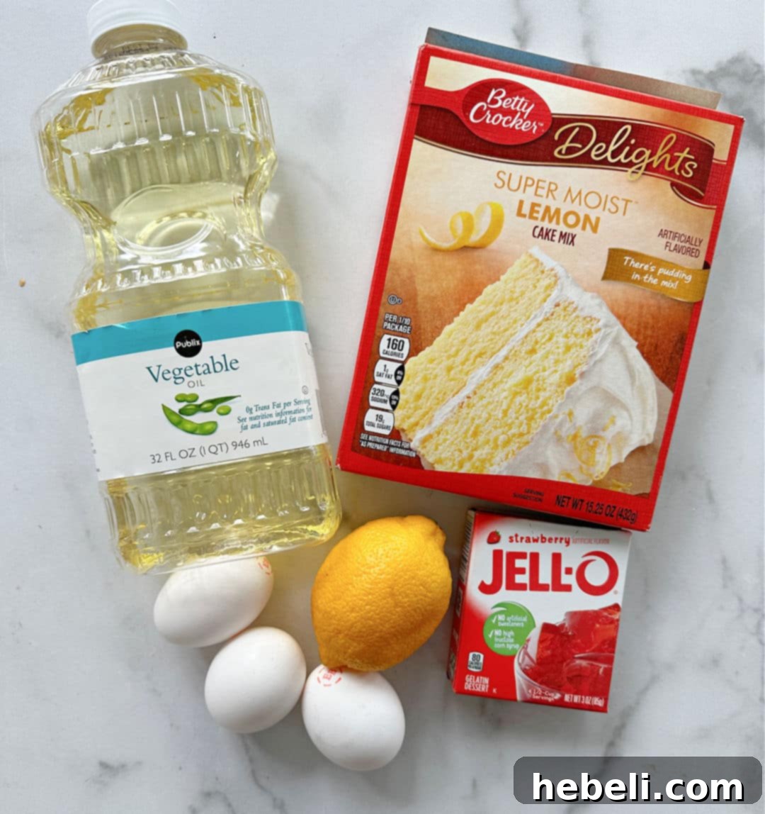 Assortment of fresh ingredients laid out, including a lemon cake mix box, fresh lemons, strawberries, gelatin, and cream cheese, for making the poke cake.