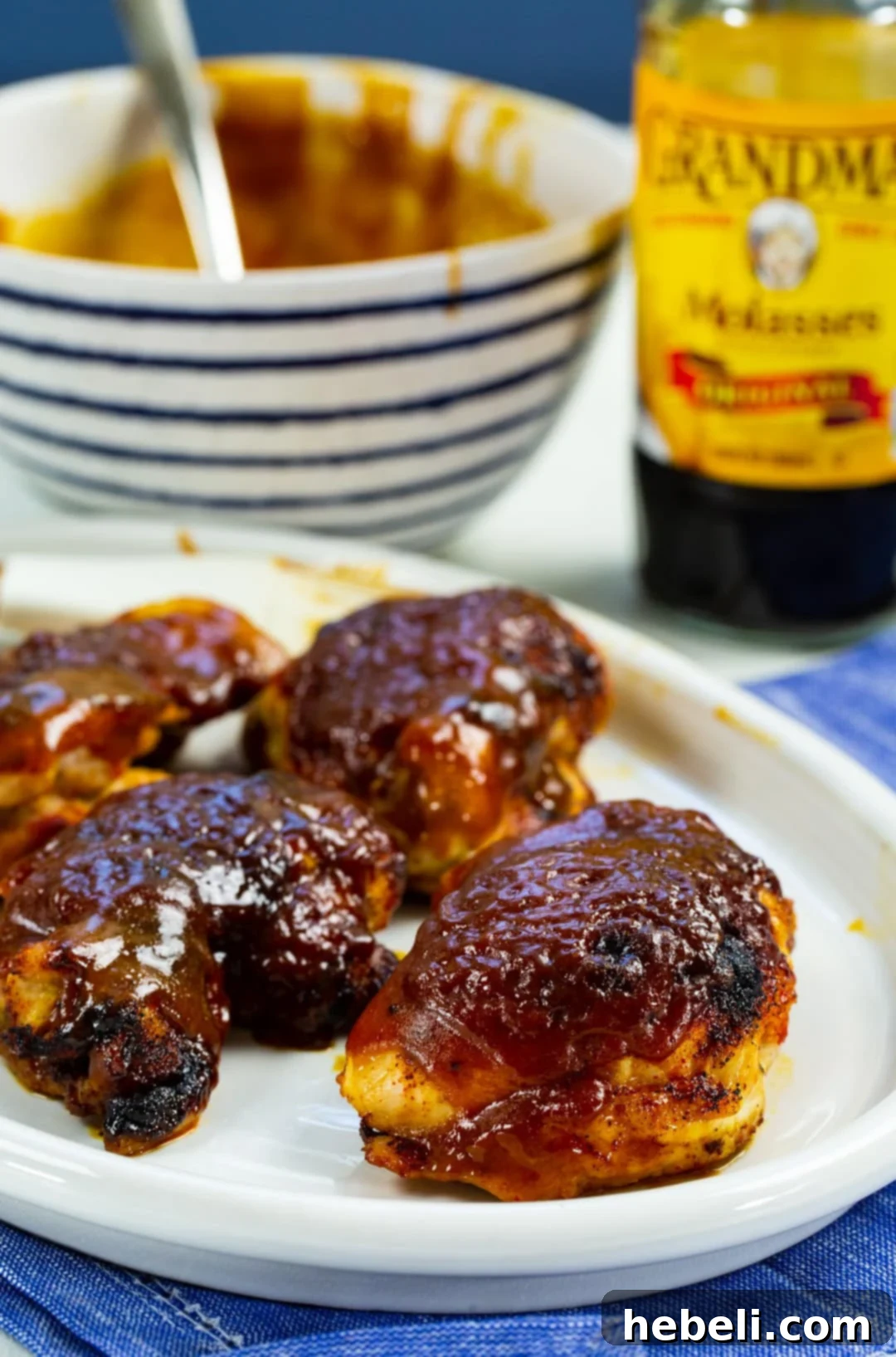 Molasses Mustard Glazed Chicken Thighs 4 Plate of cooked Molasses Mustard Chicken Thighs with a side bowl of extra glaze.