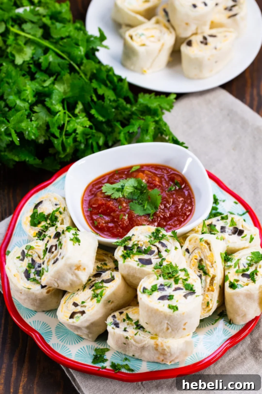 Neatly stacked Tortilla Pinwheels on a white plate, showcasing their spiraled layers.