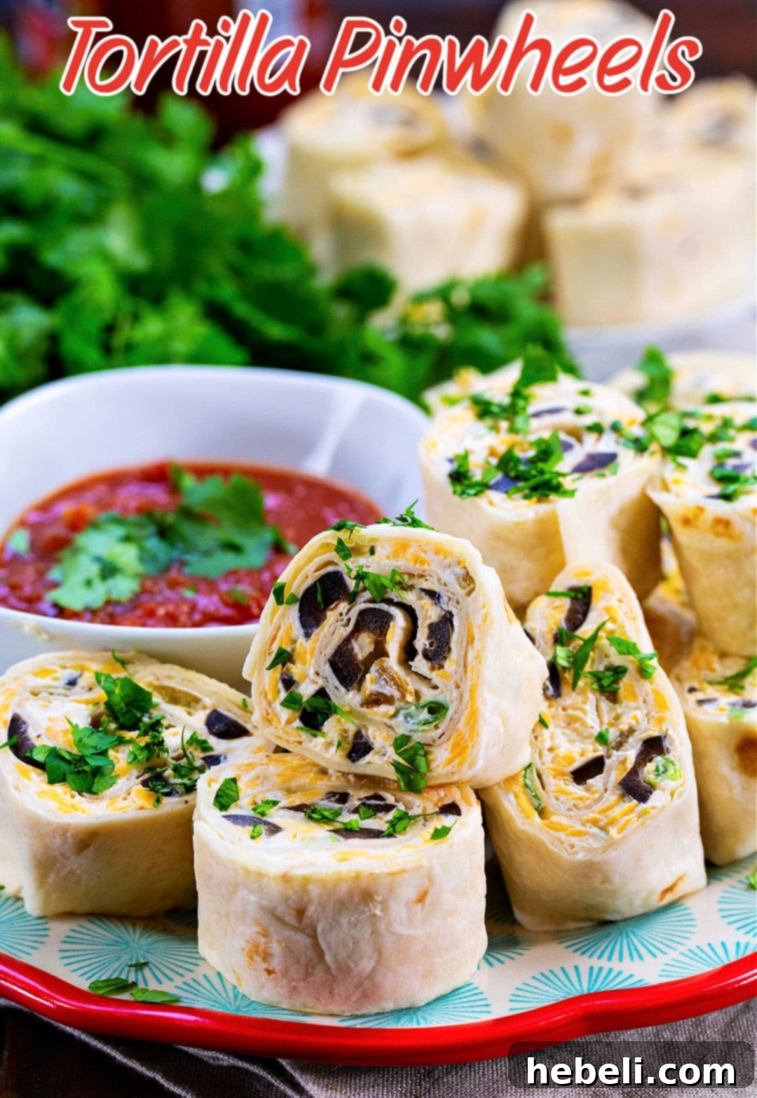 A vibrant platter of Tortilla Pinwheels alongside a bowl of salsa, garnished with fresh cilantro.