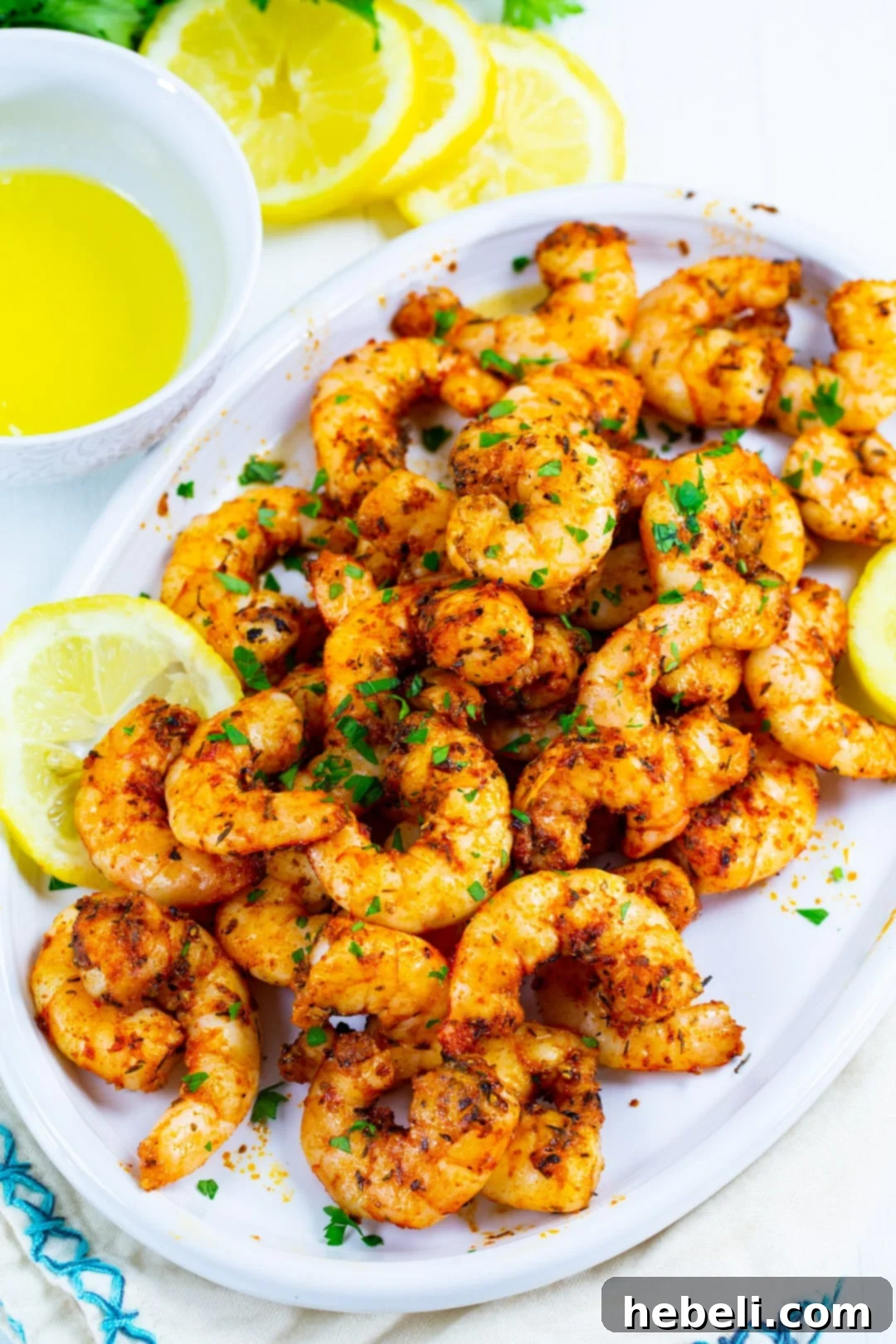 Serving platter filled with an abundance of Air Fryer Cajun Shrimp, garnished and ready to serve.