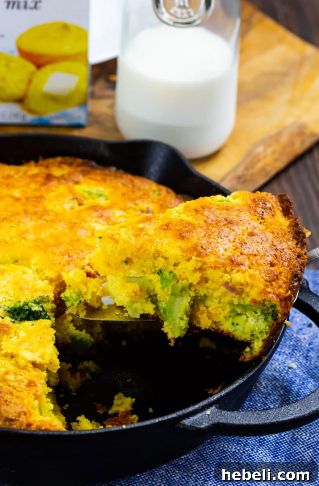 A slice of Broccoli and Ham Cornbread being carefully lifted from the skillet, showcasing its appealing texture.