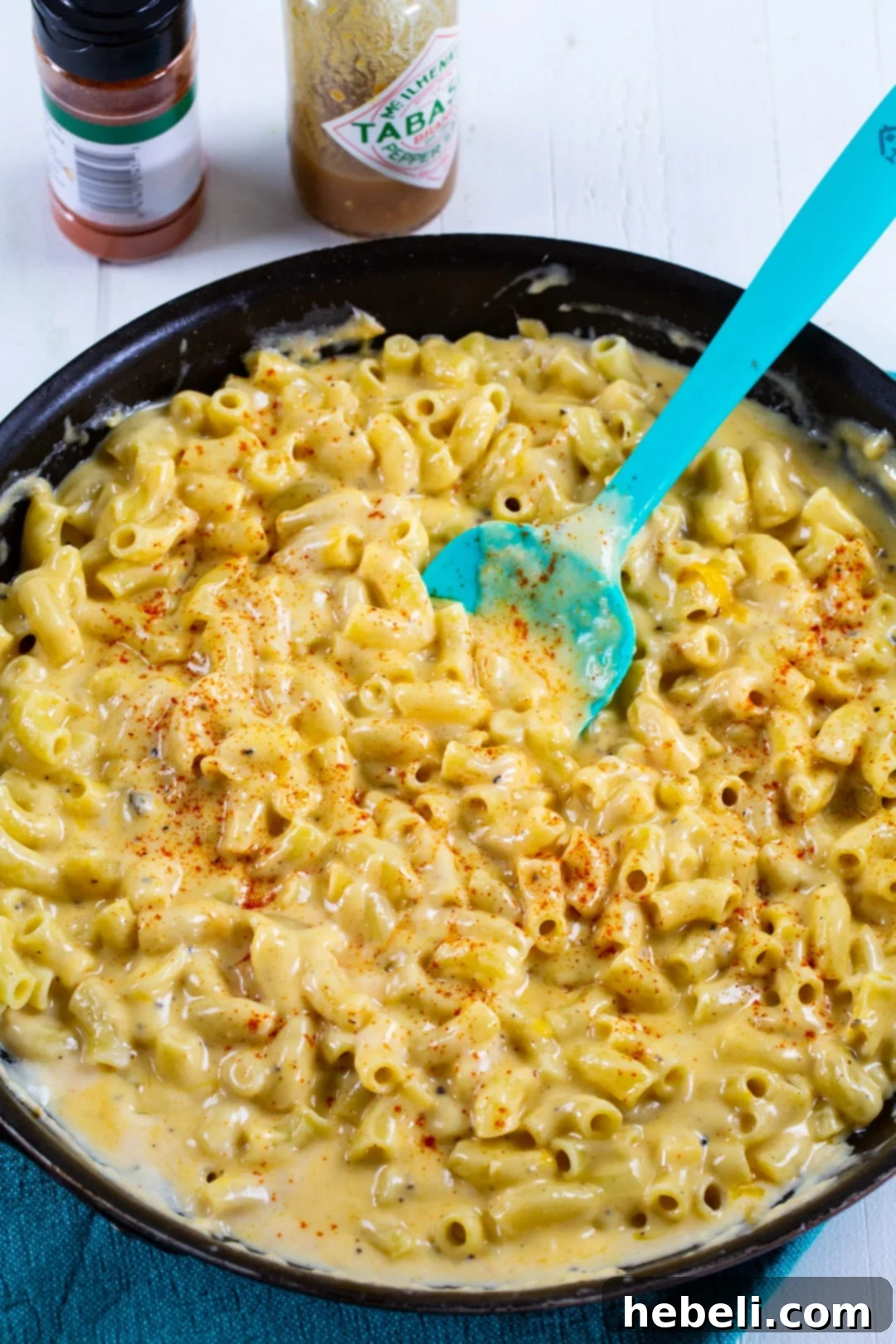 Spicy Mac and Cheese simmering in a skillet, showcasing the rich, creamy cheese sauce.