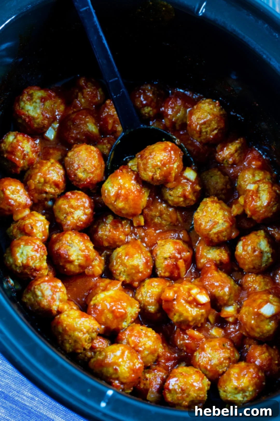 Tender Slow Cooker BBQ Meatballs 3 Close-up of BBQ Meatballs simmering in a slow cooker, surrounded by rich, thick sauce.
