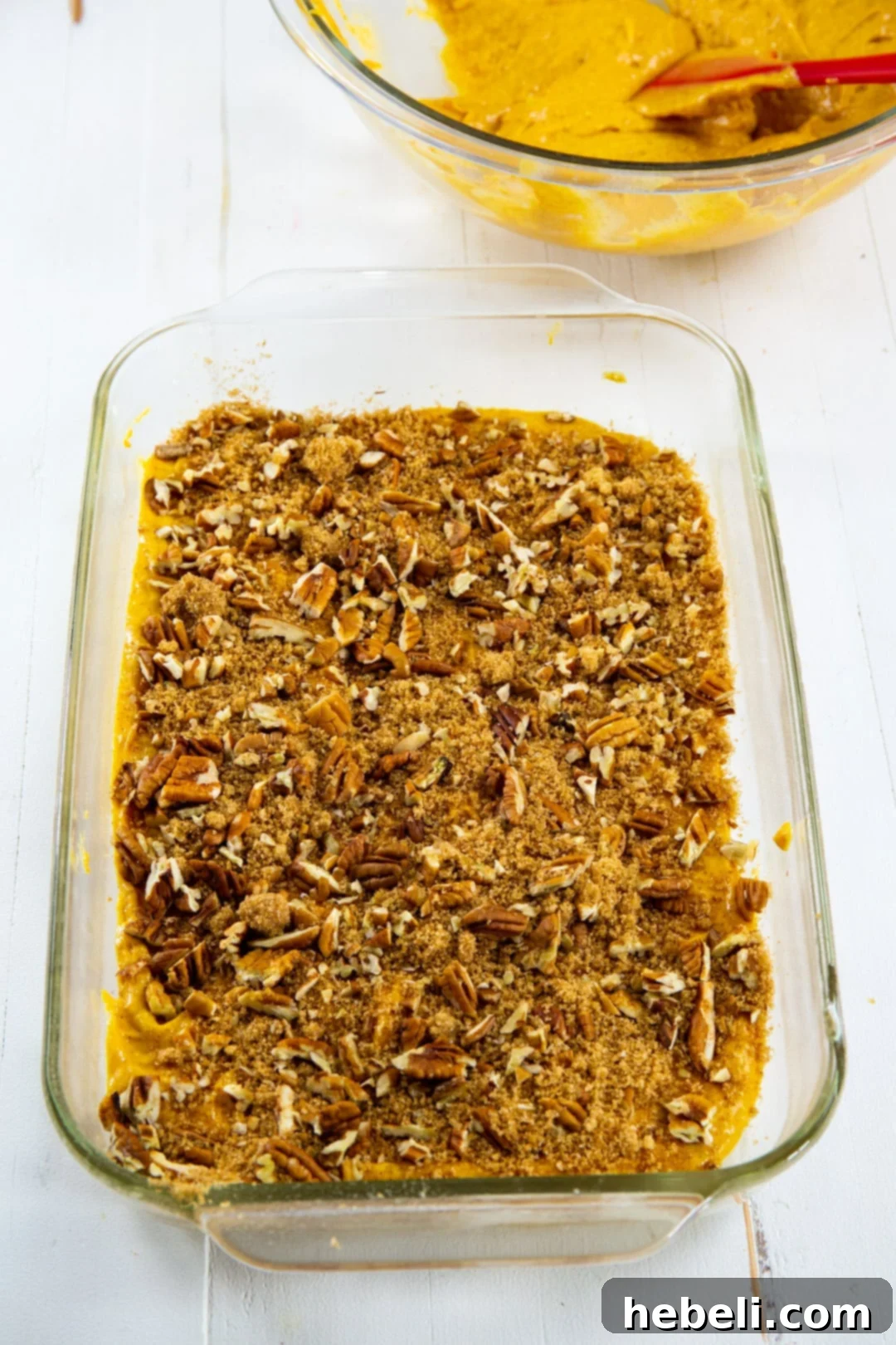 Honey Glazed Pumpkin Swirl Cake 4 Brown sugar, pecan, and cinnamon mixture sprinkled over the first layer of pumpkin cake batter in a baking dish.