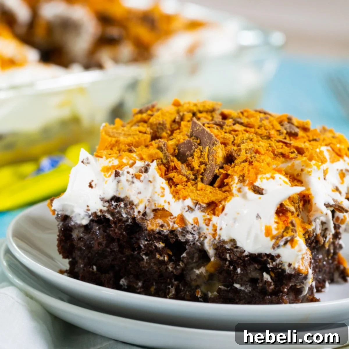 Piece of Butterfinger Poke Cake on a plate.