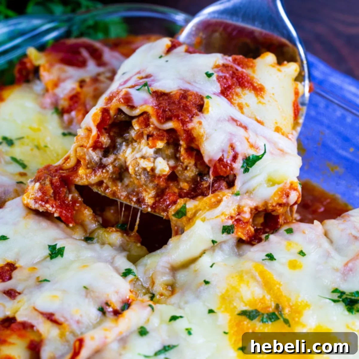 Delicious Italian Sausage Lasagna Roll-Up being served with a spatula.