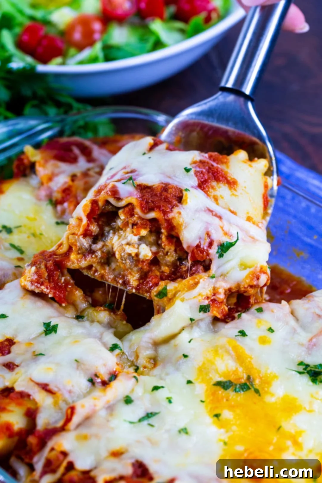 Golden brown Italian Sausage Lasagna Roll-Up being served hot from the baking dish.