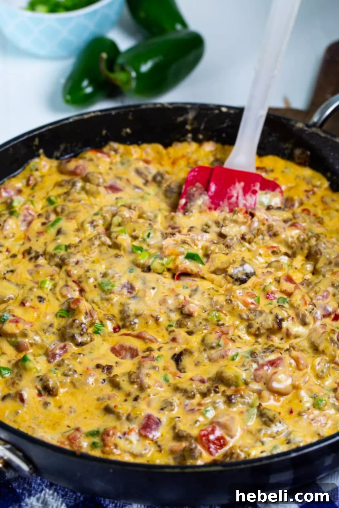 Savory Sausage Pimento Cheese Dip 3 Sausage Pimento Cheese Dip simmering in a nonstick skillet, close up.