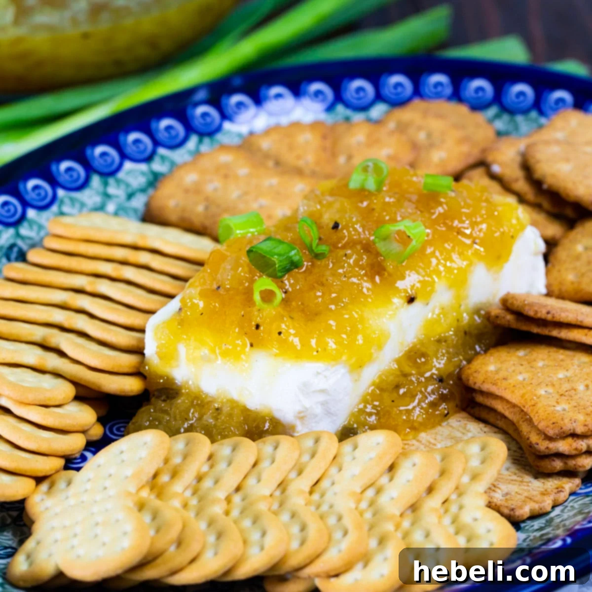 Jezebel Sauce generously spooned over a block of cream cheese, artfully arranged and ready for serving.