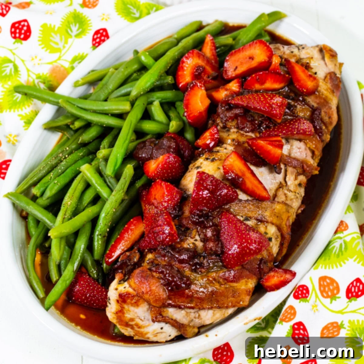 Strawberry Balsamic Glazed Pork Tenderloin 2 Perfectly cooked Pork Tenderloin with Balsamic Strawberries, served alongside crisp green beans on an elegant serving plate, ready to be enjoyed.