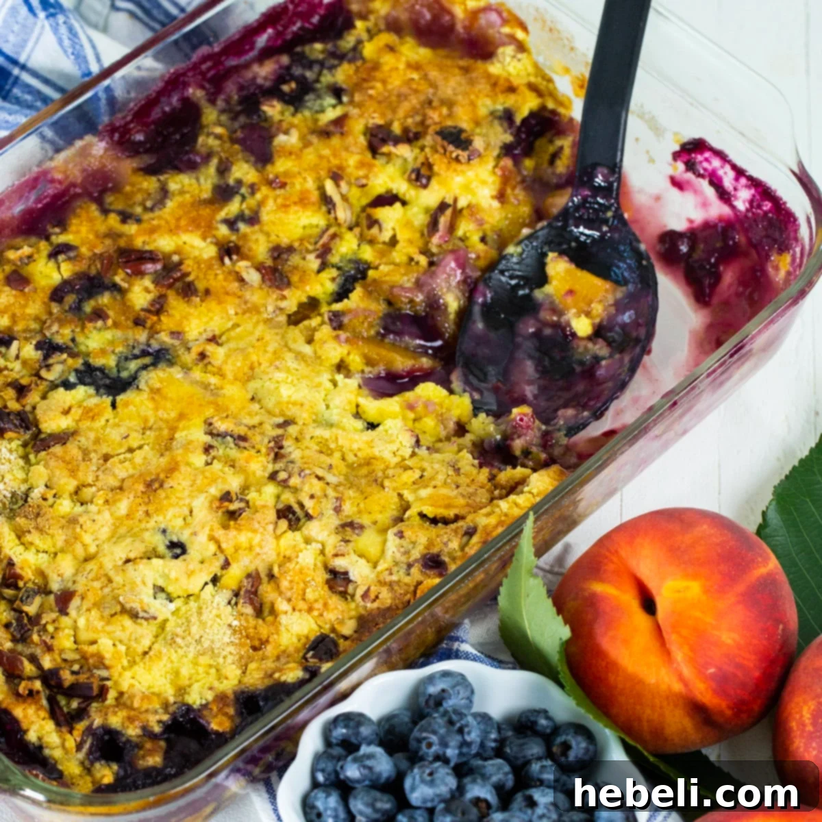 Blueberry Peach Dump Cake baked to golden perfection in a 9x13-inch baking pan, ready to be served, topped with a scoop of melting vanilla ice cream.