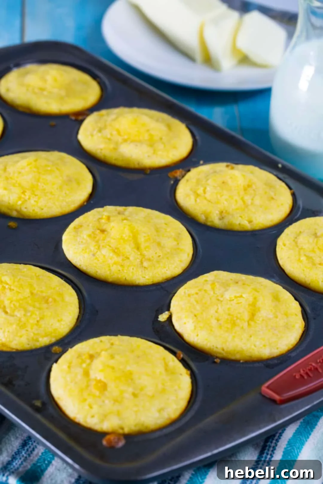 Freshly baked Creamed Corn Cornbread Muffins cooling in a muffin tin.