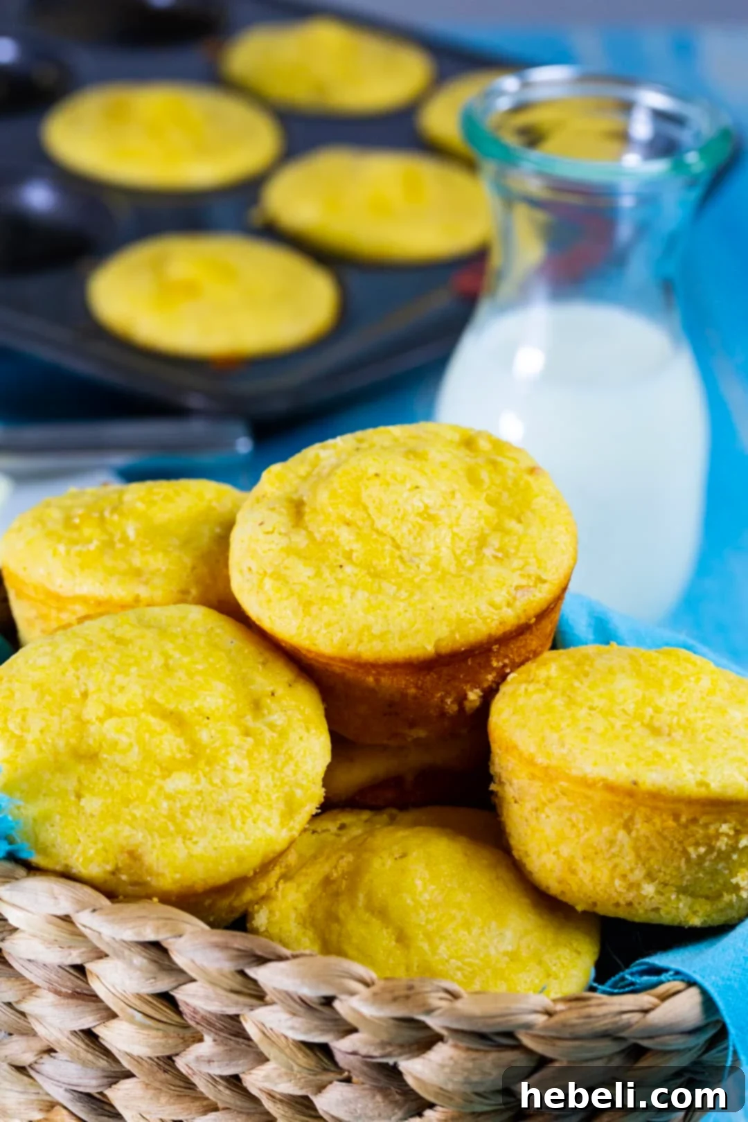 Close-up of Creamed Corn Cornbread Muffins in a bread basket, showcasing their golden crust and fluffy interior.